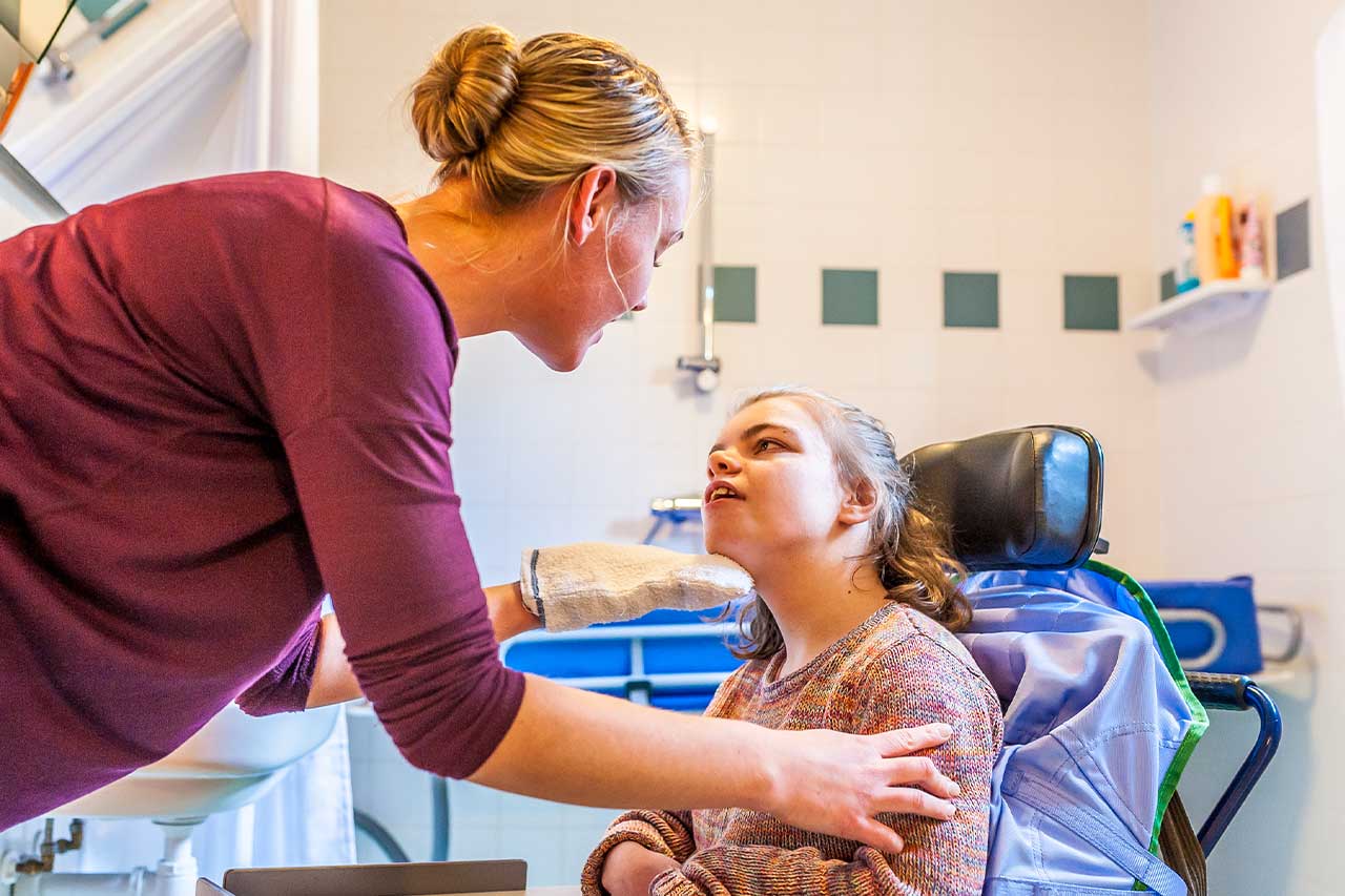 Carer assisting a young person at home